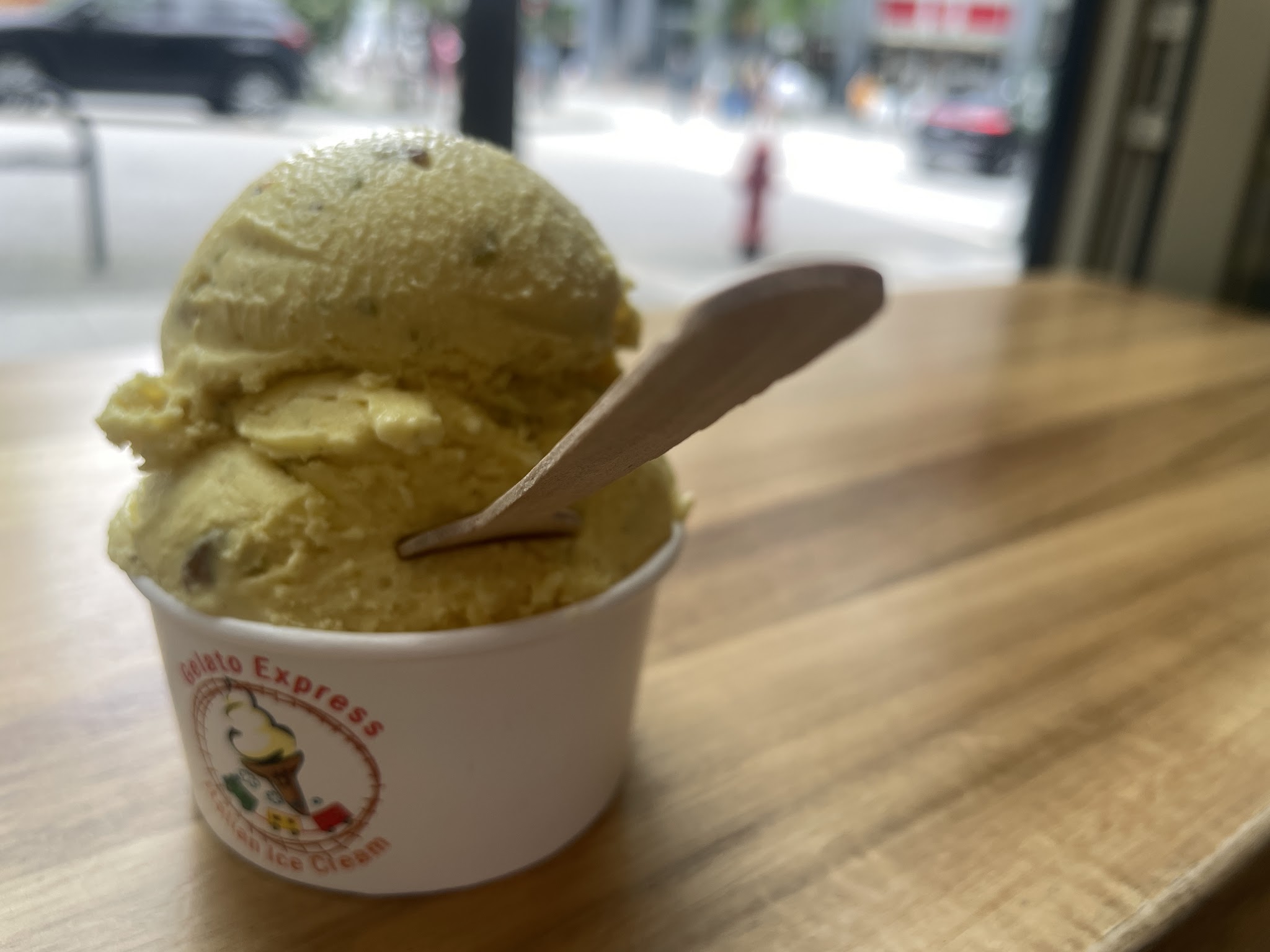 Single scoop of pistachio gelato in a branded Gelato Express cup