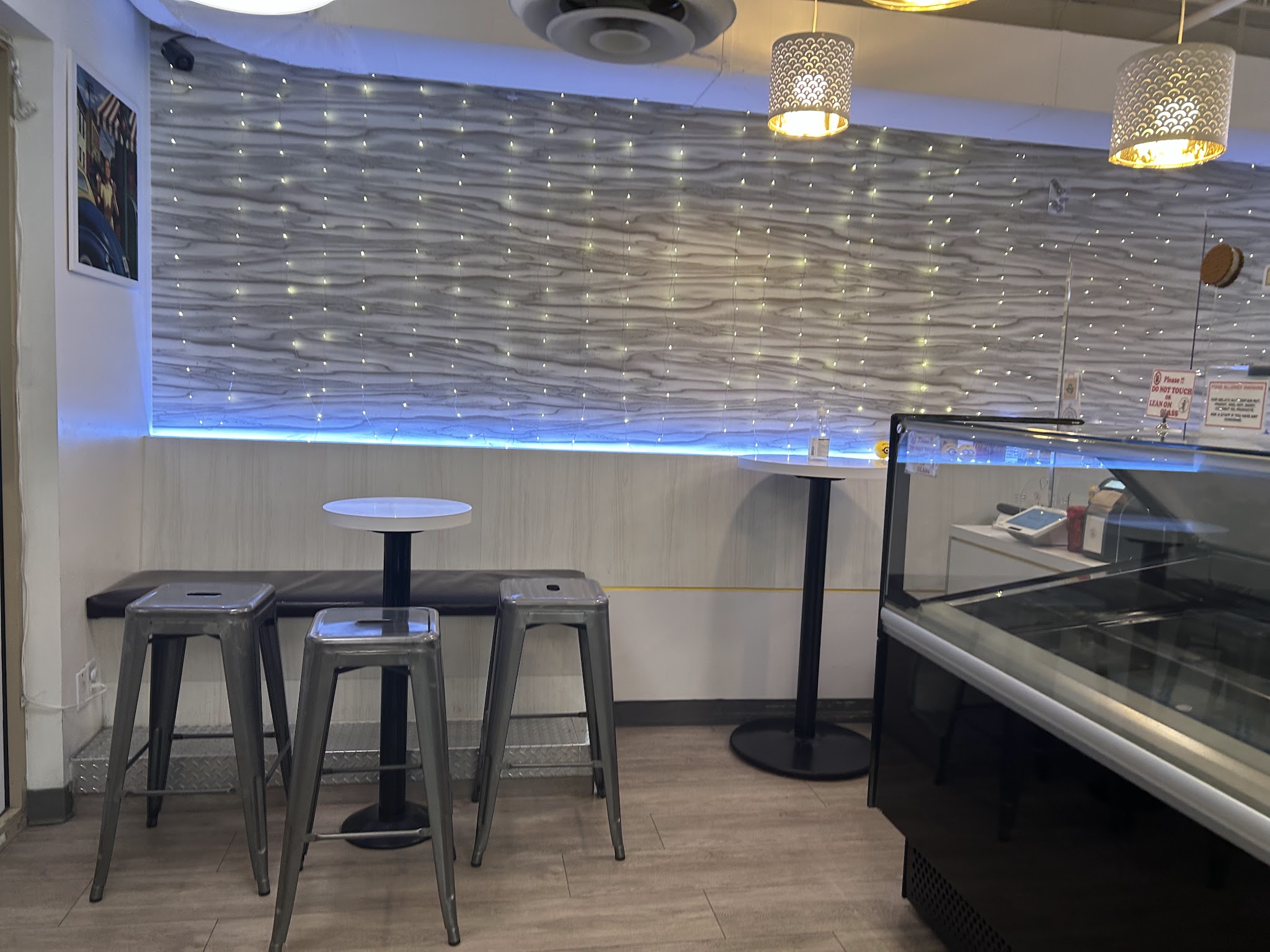Seating area with industrial stools, wave-textured wall, and blue LED accent lighting