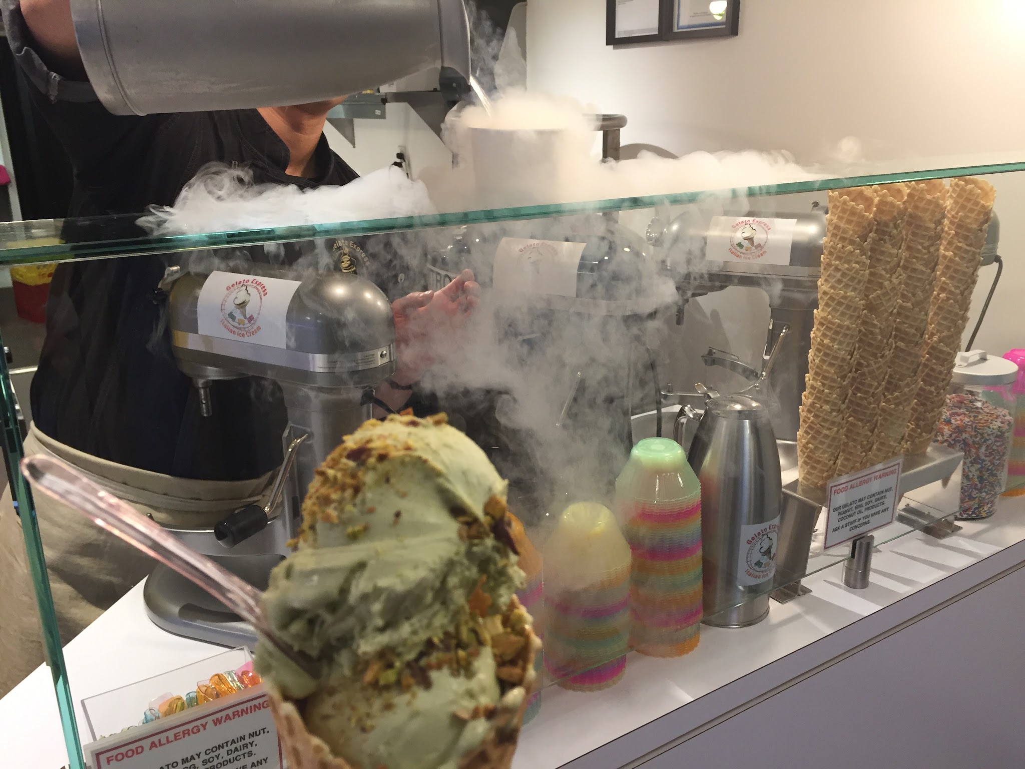 Fresh gelato being made with nitrogen process, smoke billowing from mixer